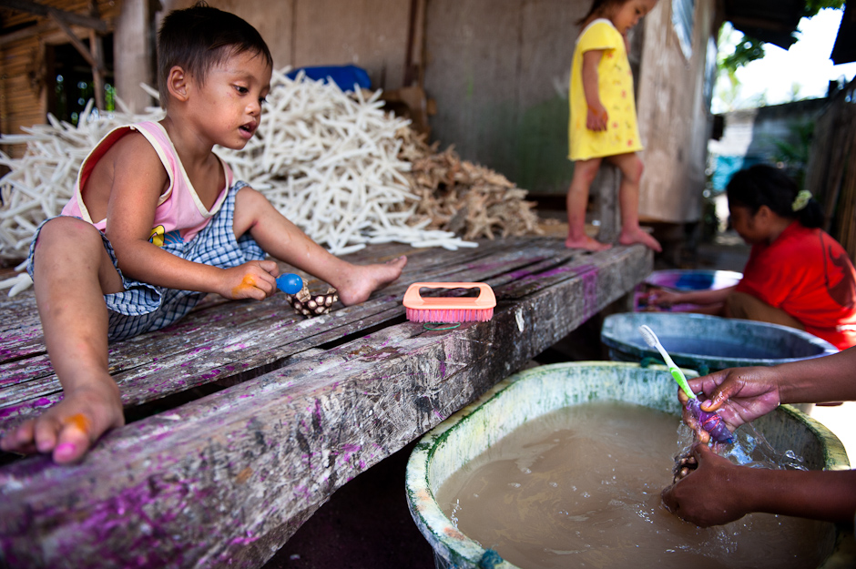 Children watching their mothers clean sea urchins.