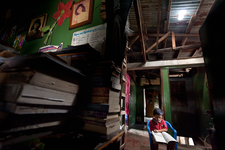 Child reading under a solar powered light
