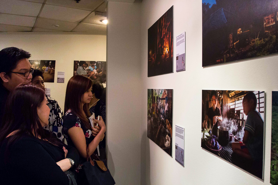 Panel arrangement and visitors looking at photos.