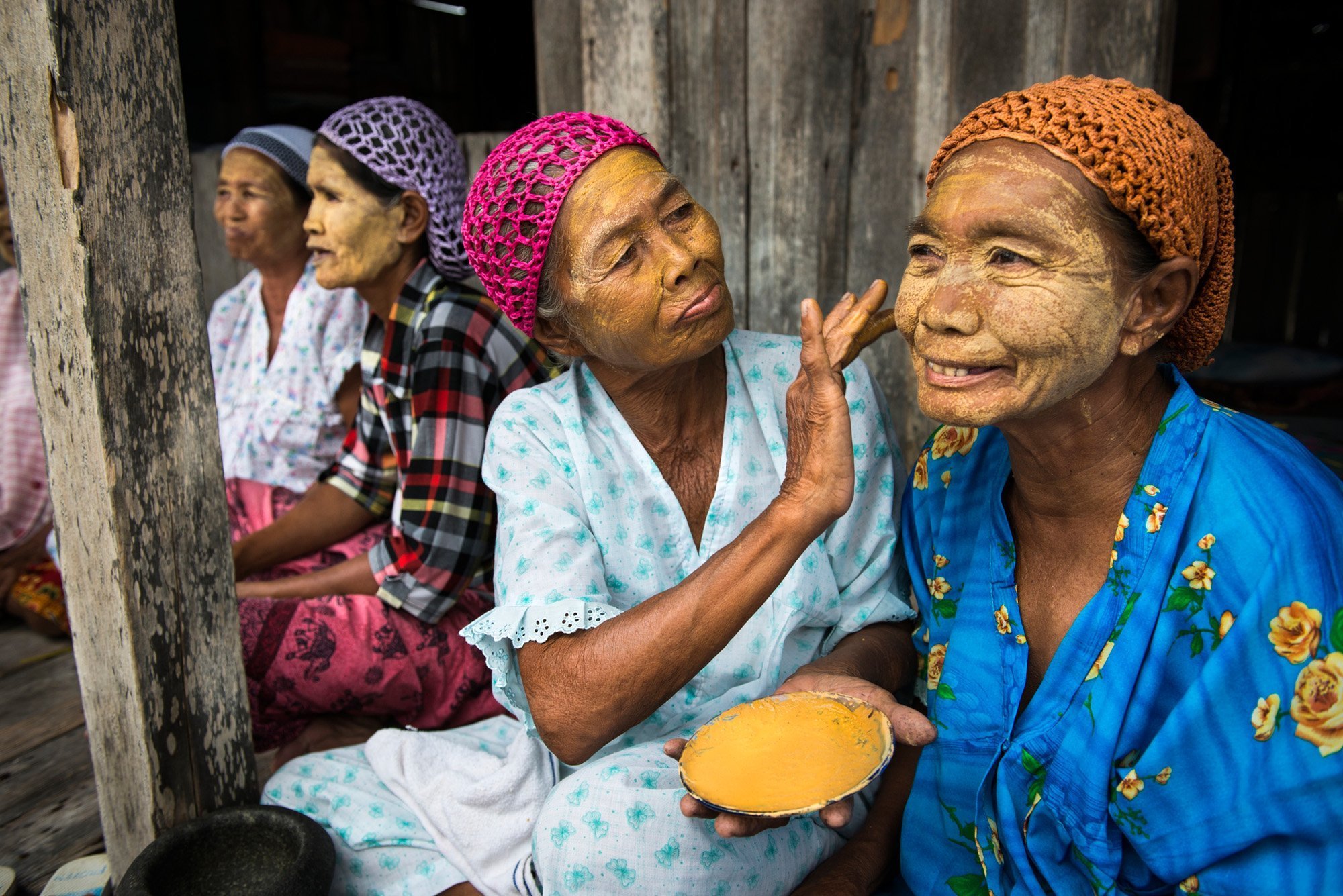 Tawi_Tawi_0429_1201 Sama-Bajau women applying a natural paste on their faces which they call burak. The paste is made from pounded rice, turmeric and some other ingredients to beautify their faces and act as a natural sunblock. (Tawi-Tawi, Philippines)